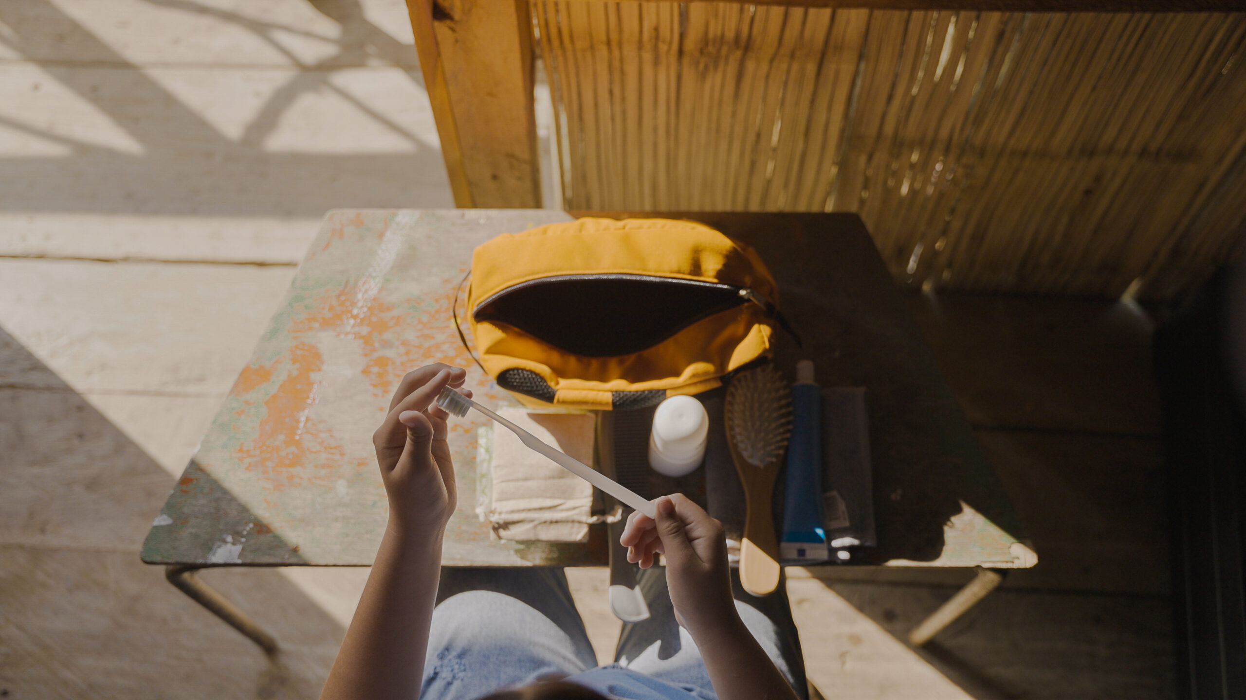 A child’s hands unpacks a World Vision hygiene kit with hair brush and toothbrush