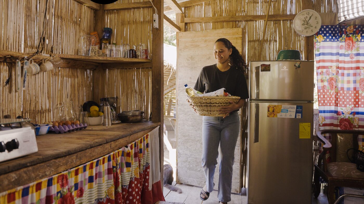Teenage girl brings in food basket in Ecuador.