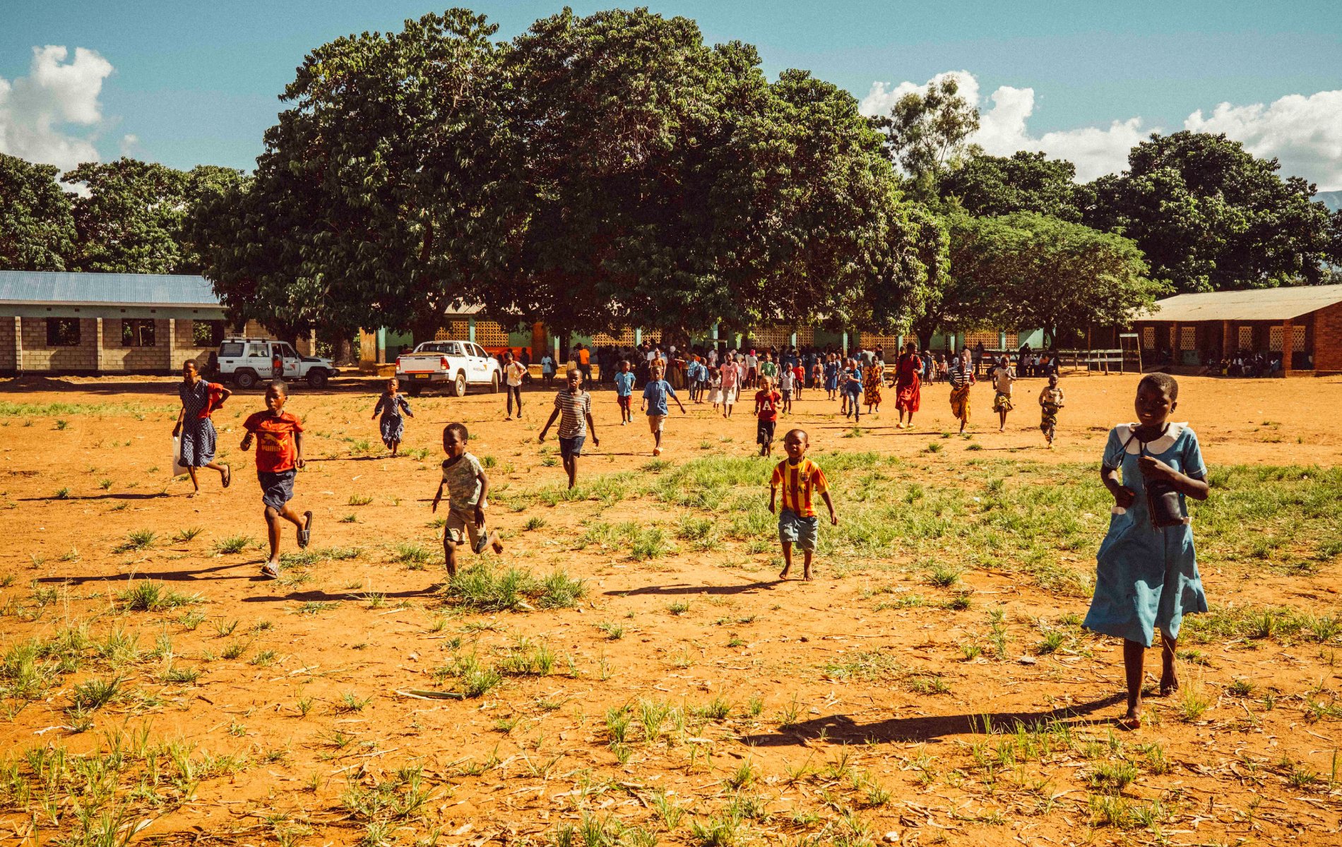 Children of various ages run through their schoolyard.