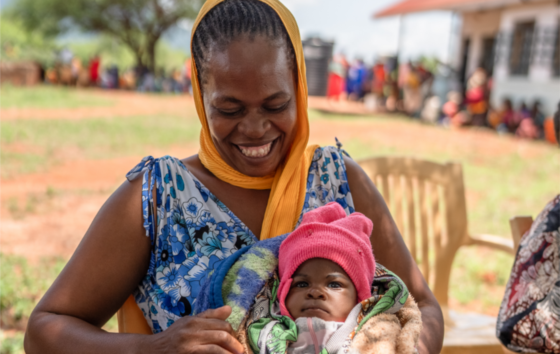 A mother gazes lovingly at the baby on her lap.